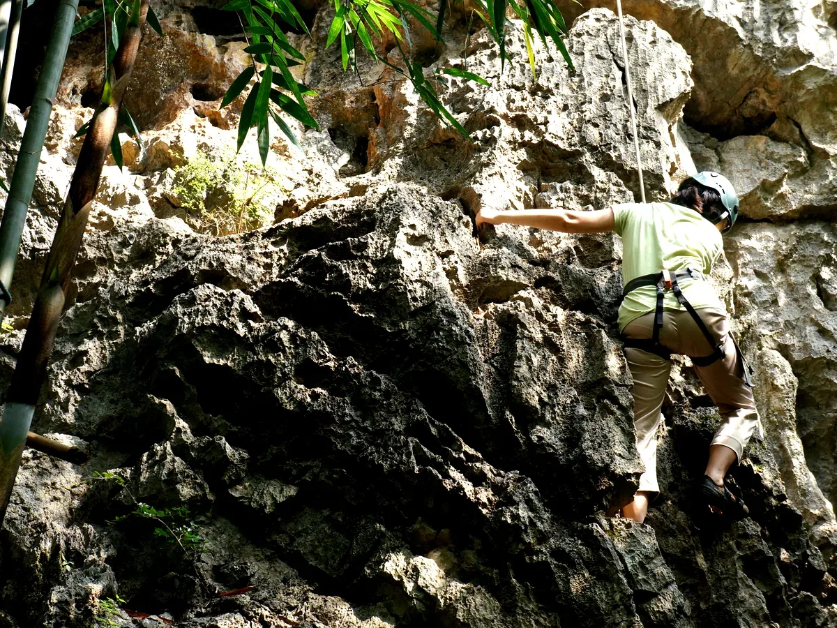 A child and parent climbing together on China's karst limestone with a guide