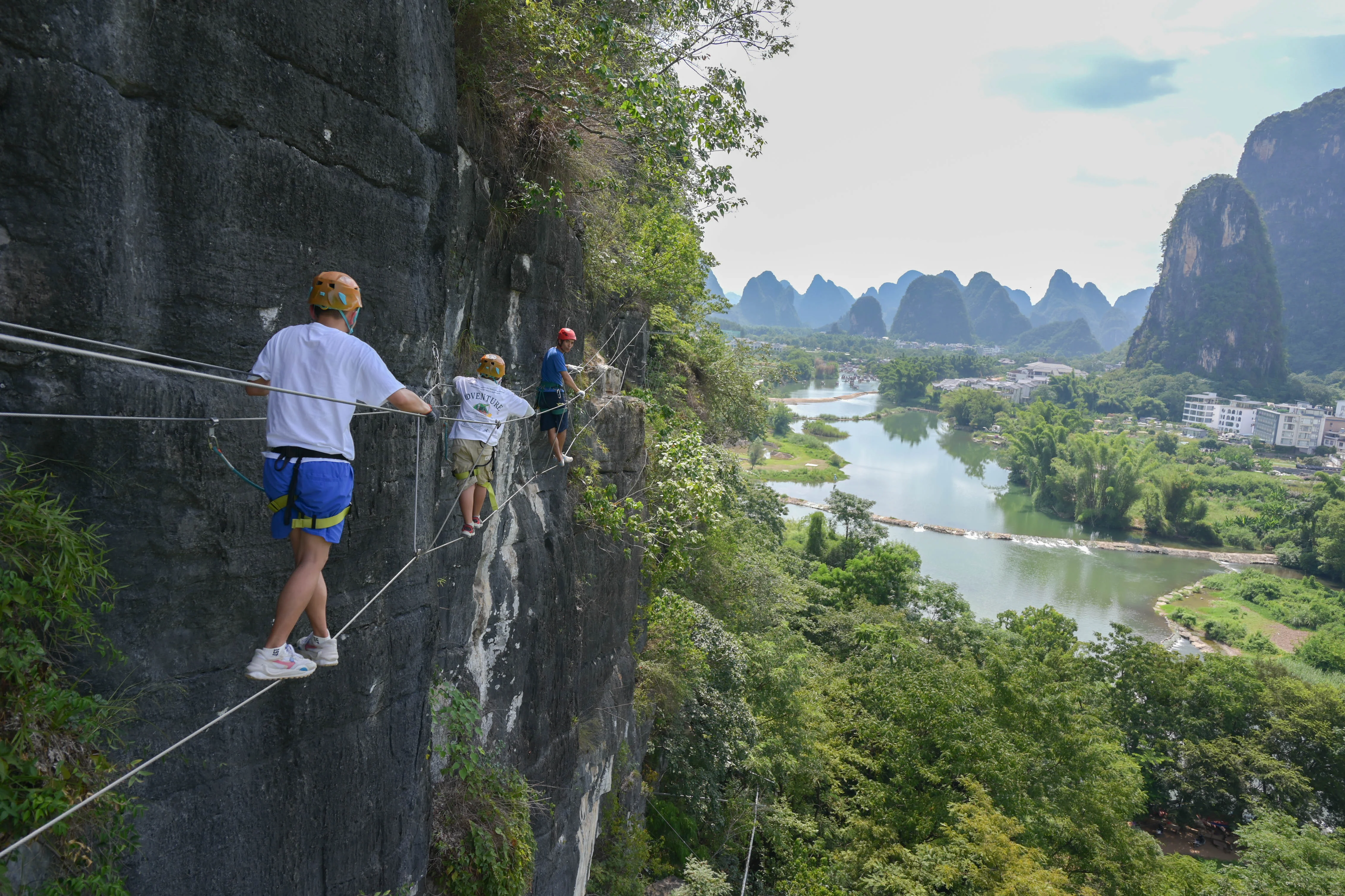 Guide briefing participants on via ferrata technique at the cliff entrance in China