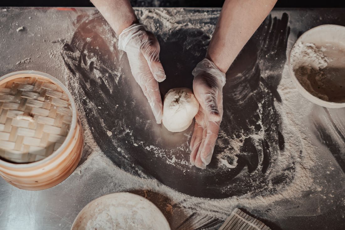Hands folding dim sum dumplings