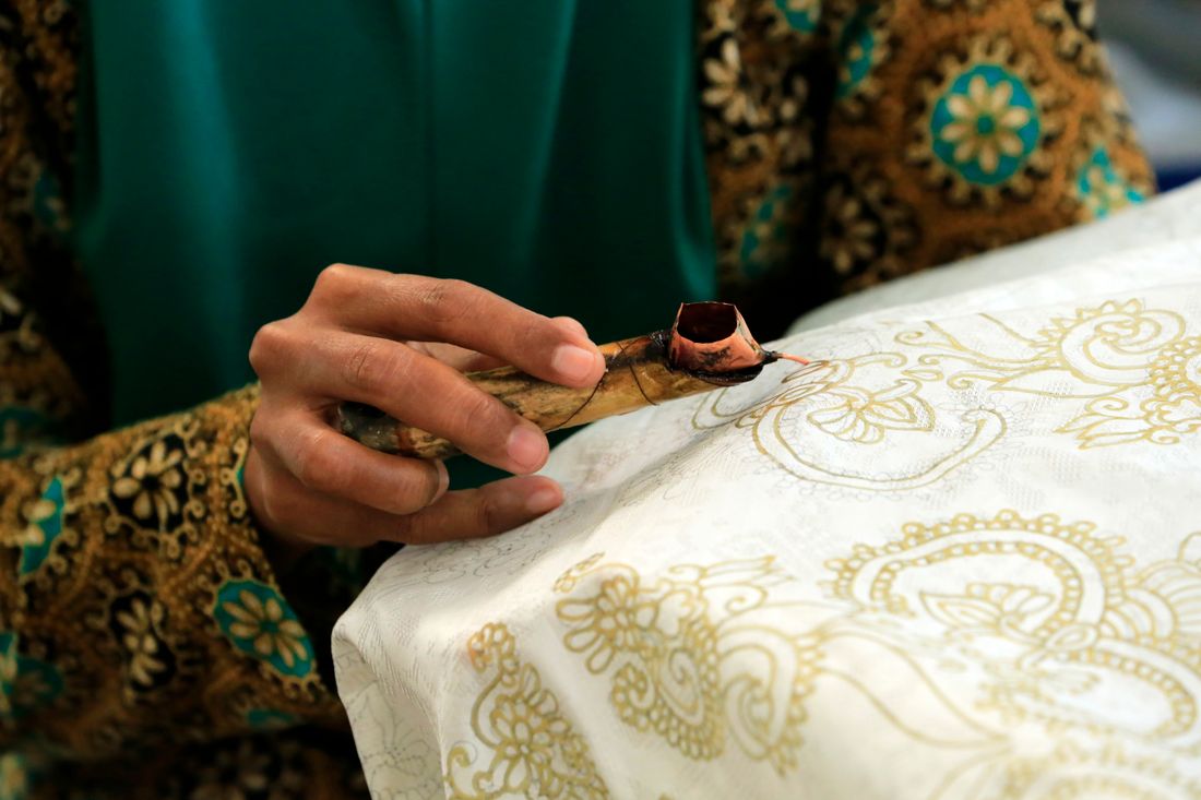 Hand painting batik wax-resist fabric in Guizhou