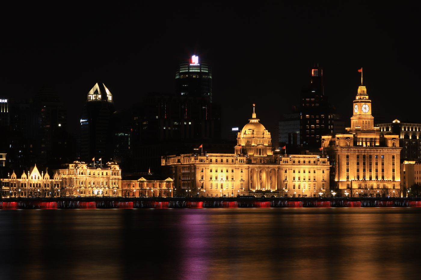 Shanghai Bund illuminated at night with the Pudong skyline across the Huangpu River