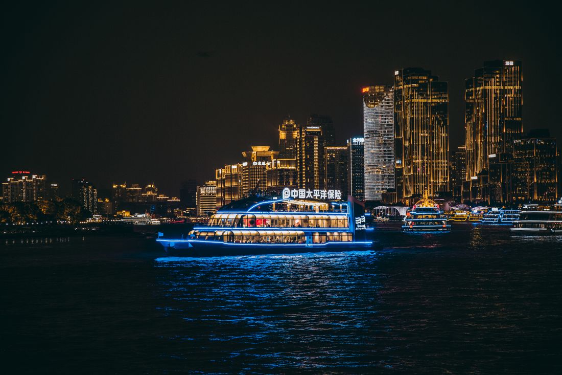 Cruise ship on Huangpu River, Shanghai skyline at night