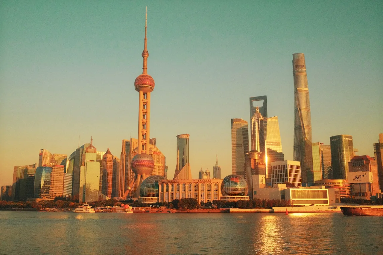 Modern Shanghai skyline with Pudong towers reflected in the Huangpu River at sunset