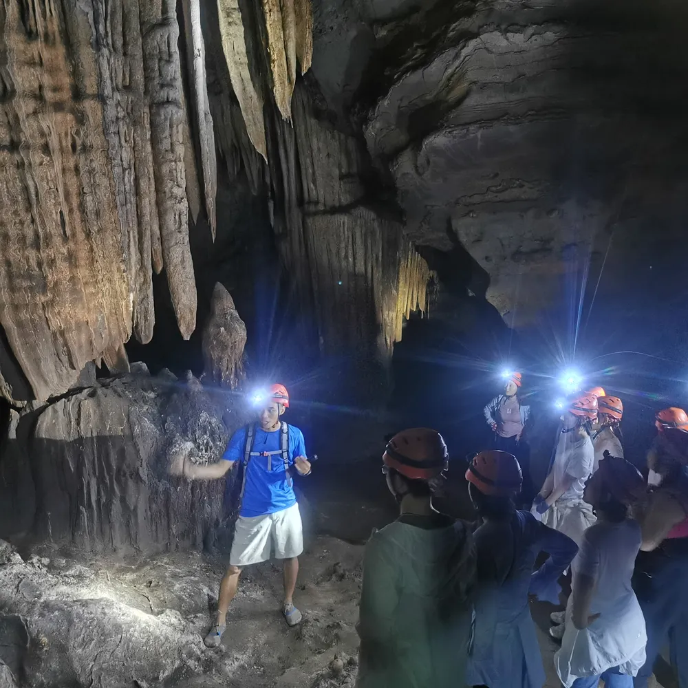 Guest exploring a cave with China Trailfolk