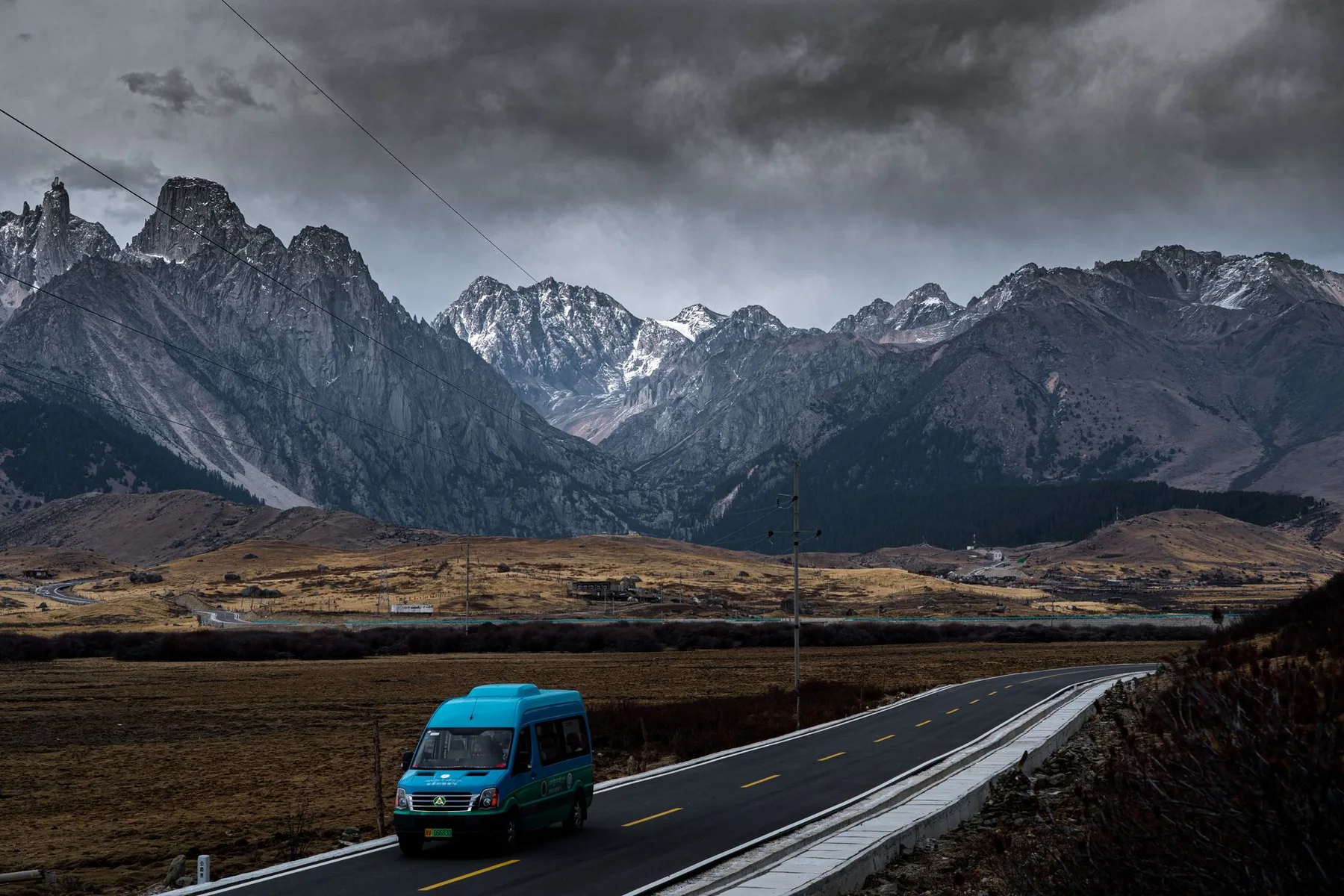 Blue van on a mountain highway for a guided China RV road trip