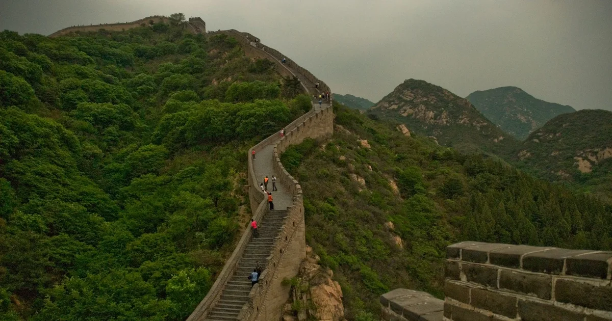 Great Wall of China winding across green mountain ridges near Beijing for a hiking guide